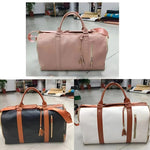 Chic-Fold 75L travel duffel bags in pink, black, and white with brown accents, displayed in a showroom setting.