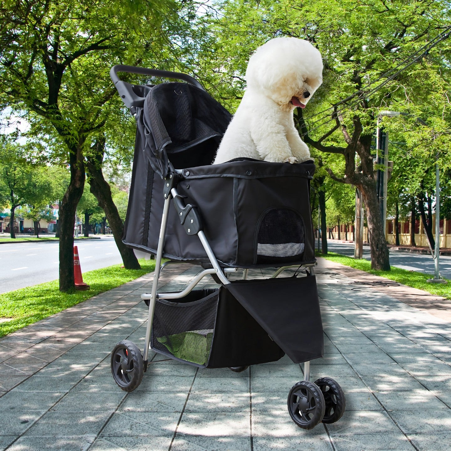 White dog seated in a lightweight foldable pet stroller with breathable mesh windows, shown outdoors on a tree-lined sidewalk.