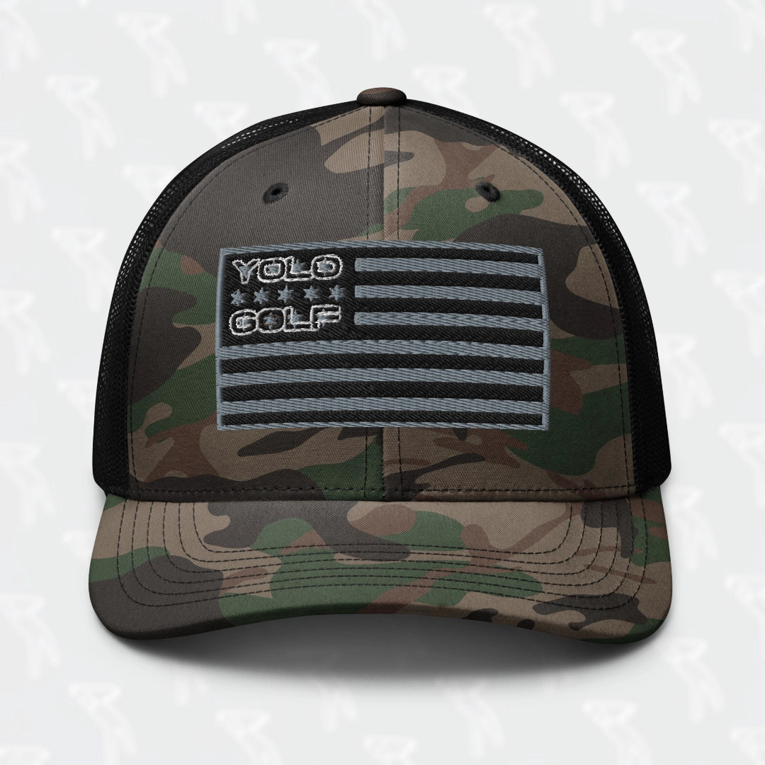 #YOLO Golf-USA Flag black camouflage trucker hat with embroidered American flag design, featuring breathable mesh back and snapback closure.