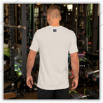 Back view of a light gray YOLO Sport t-shirt worn by a man in a gym. Minimalist design with a small logo on the upper back.