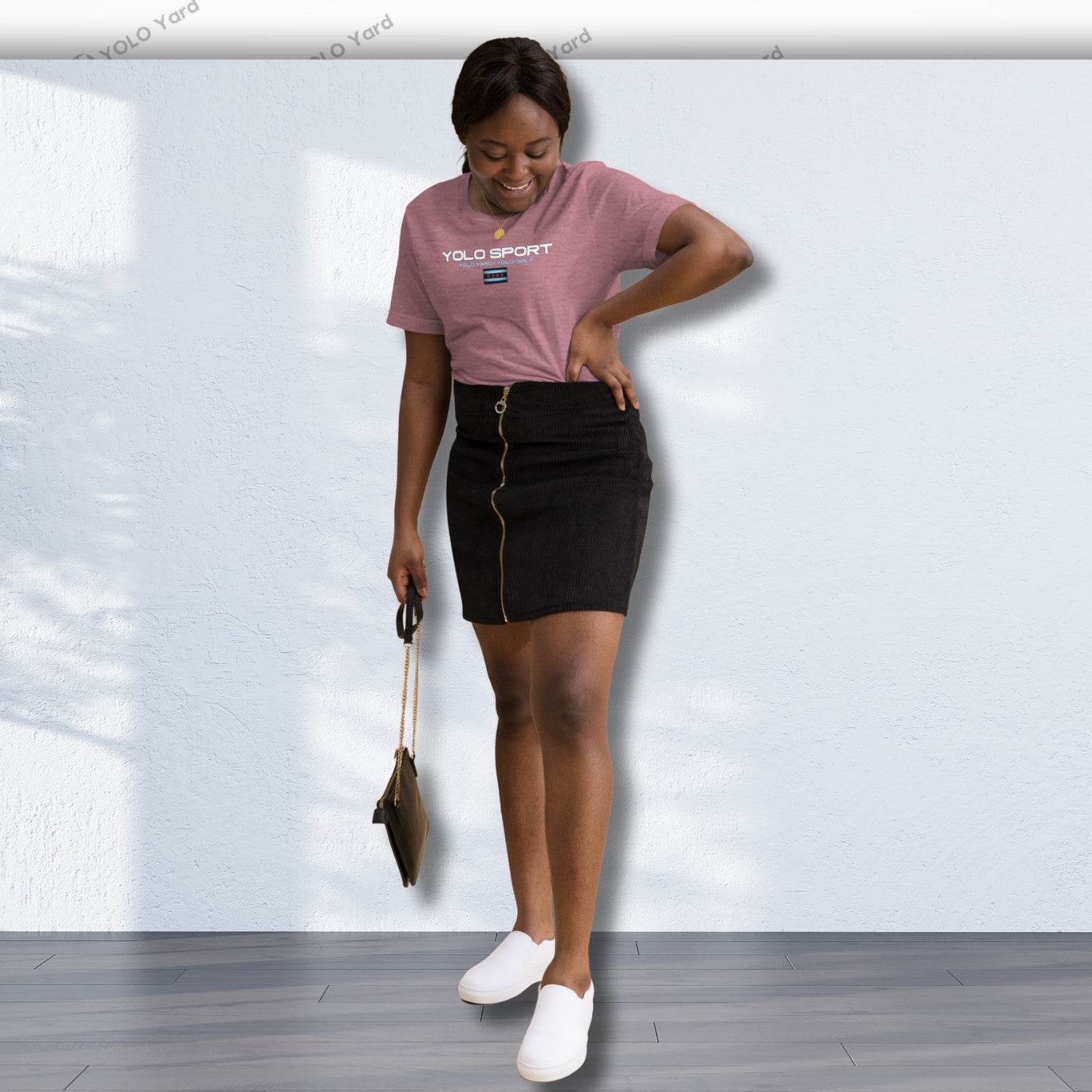 Pink YOLO Sport unisex t-shirt styled with a black skirt and white sneakers. Perfect for casual outings or athleisure looks.