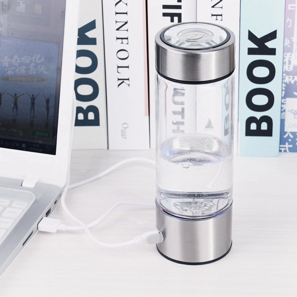 AquaPure Hydrogen Water Bottle connected to a laptop via USB, ideal for use at work or home for hydrogen-rich water.