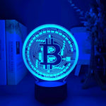 Blue-lit CryptoGlow Bitcoin 3D LED table lamp, a stylish and eye-catching decor piece for any room.