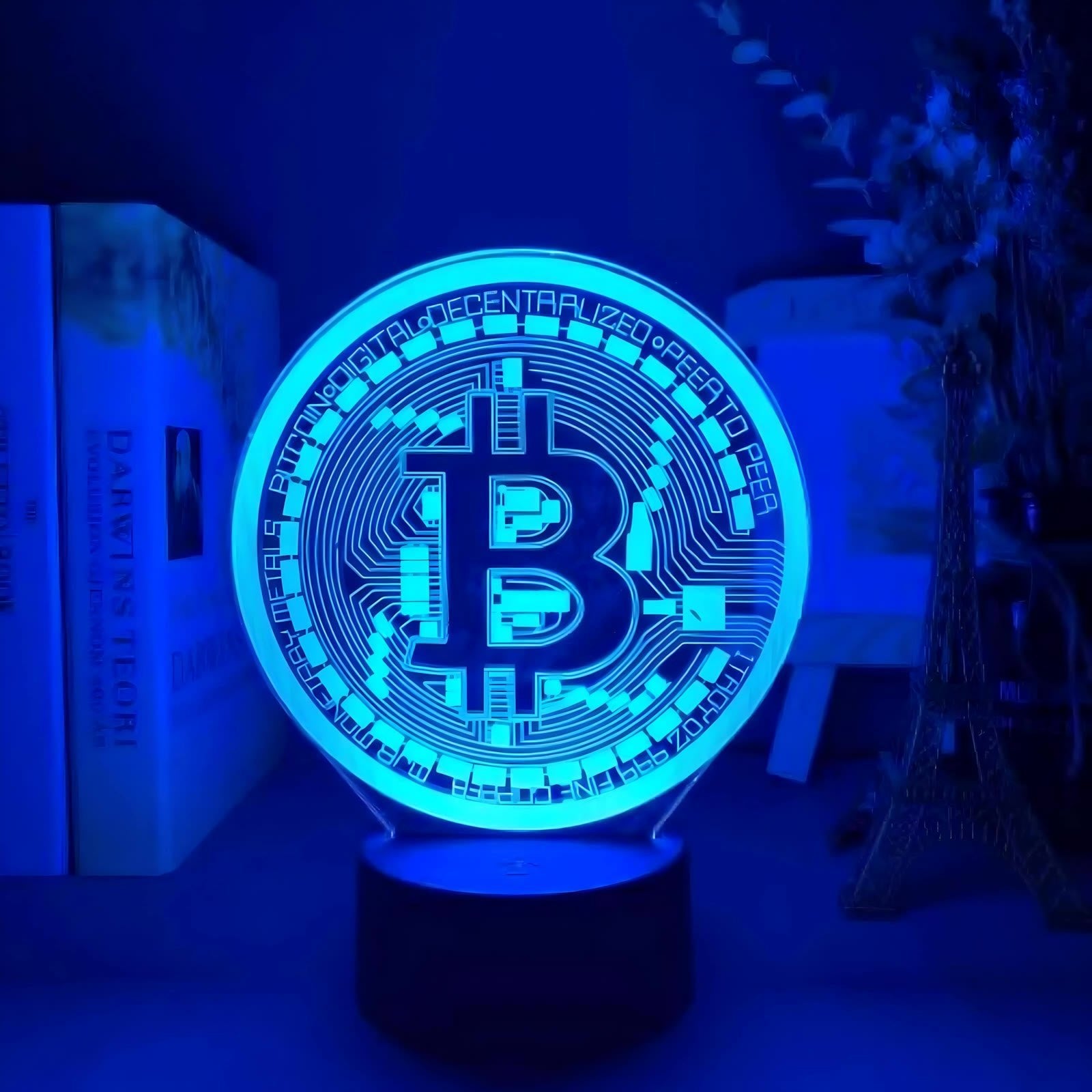 Blue-lit CryptoGlow Bitcoin 3D LED table lamp, a stylish and eye-catching decor piece for any room.