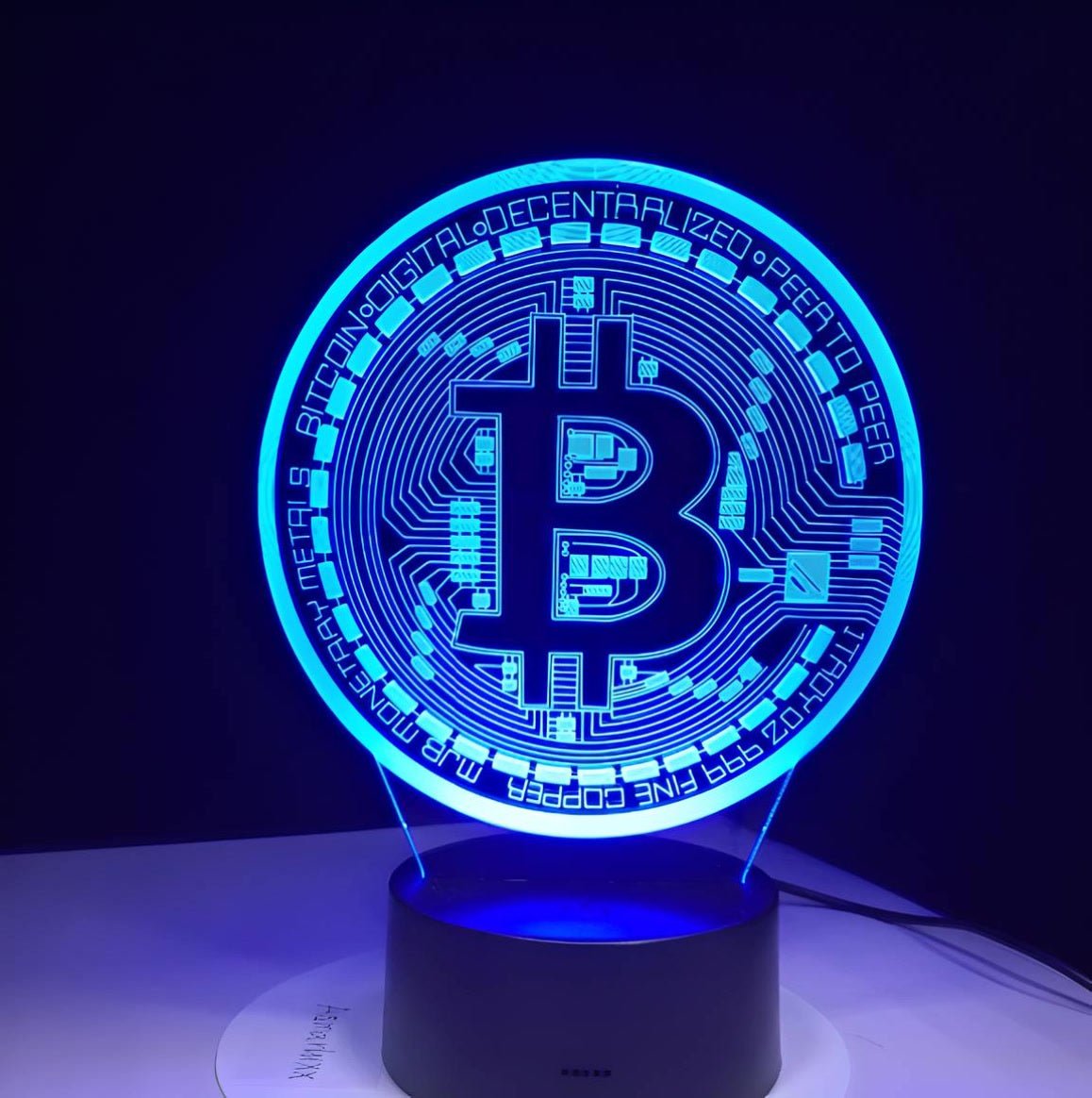 Blue-lit Bitcoin 3D LED desk lamp with a sleek black base, perfect for adding a futuristic vibe to any space.