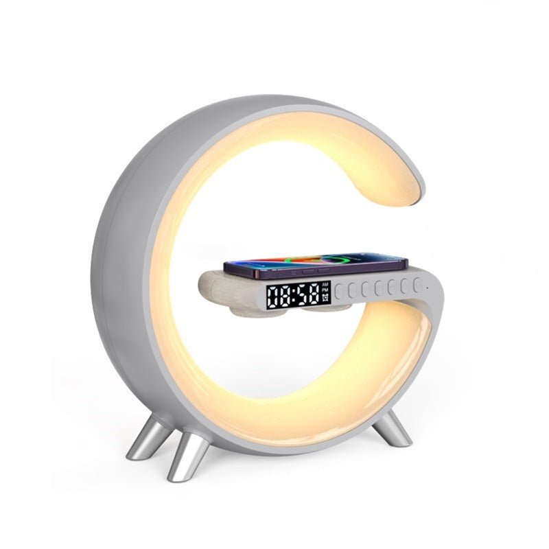 White G-shaped LED lamp with soft yellow lighting, wireless charging pad, and digital clock display for a modern and functional design.