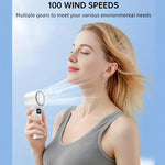 Woman enjoying the cooling effect of a white handheld turbo fan with 100 adjustable wind speeds for personalized comfort.