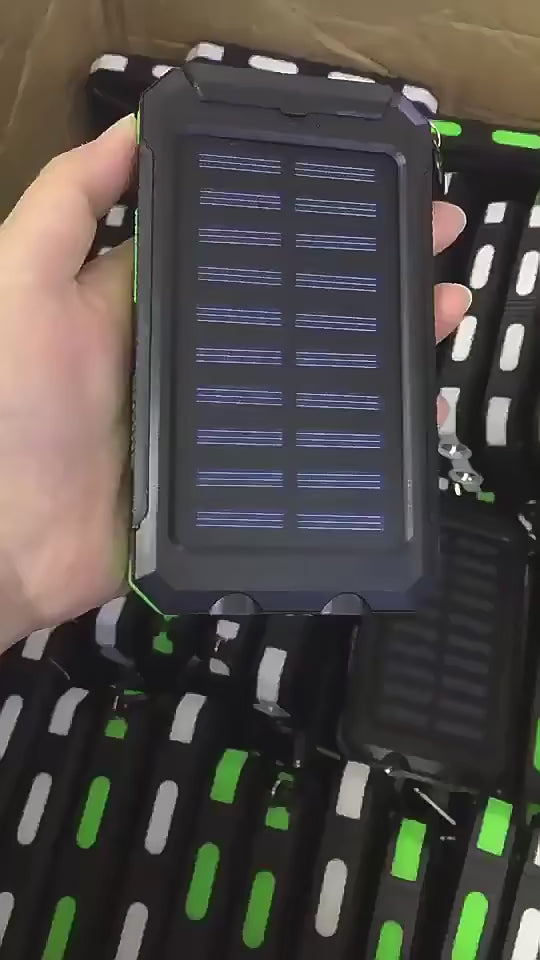 Hand holding a green-accented solar power bank, highlighting its compact and portable design for outdoor activities.