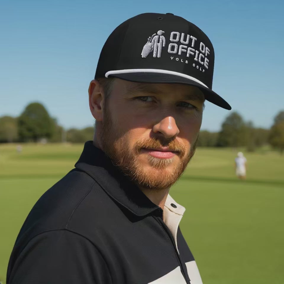 Man wearing a black 'Out of Office' golf rope cap with silver 