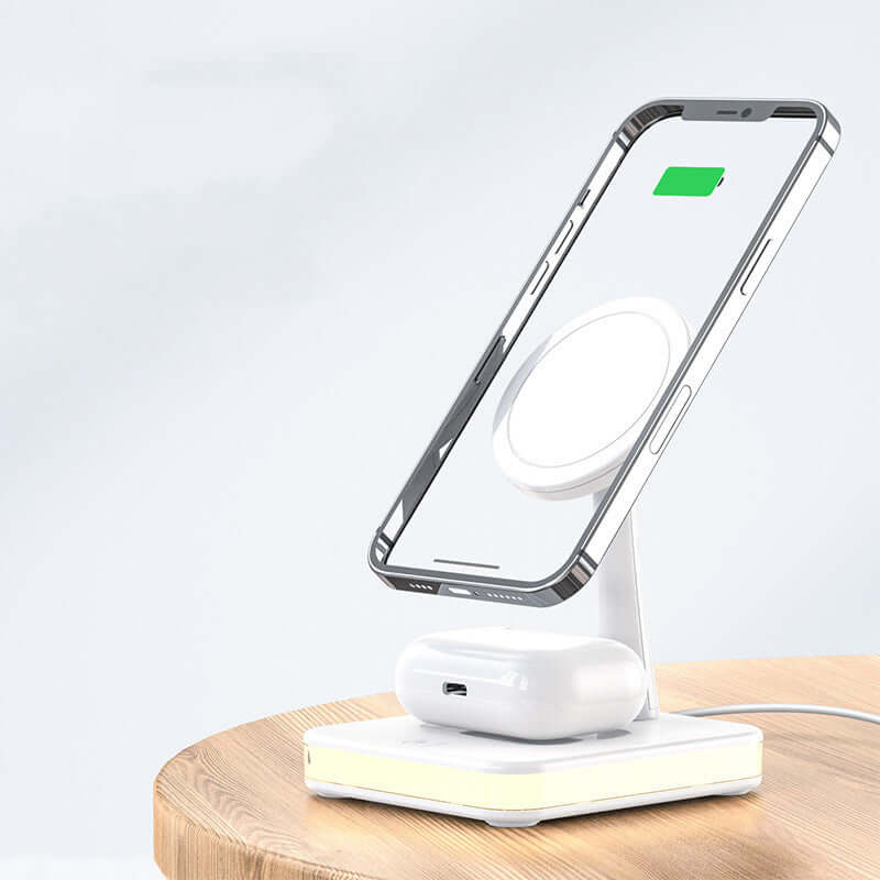 QuadraCharge LED Dock on a wooden surface, charging a phone and earbuds. Compact design with warm LED lighting for convenience.