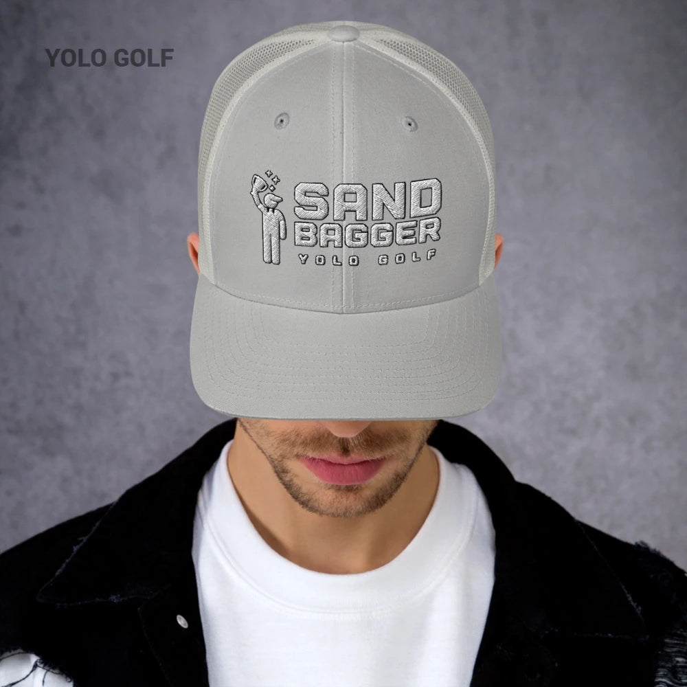 Black and white Sandbagger trucker hat worn by a man, featuring a 