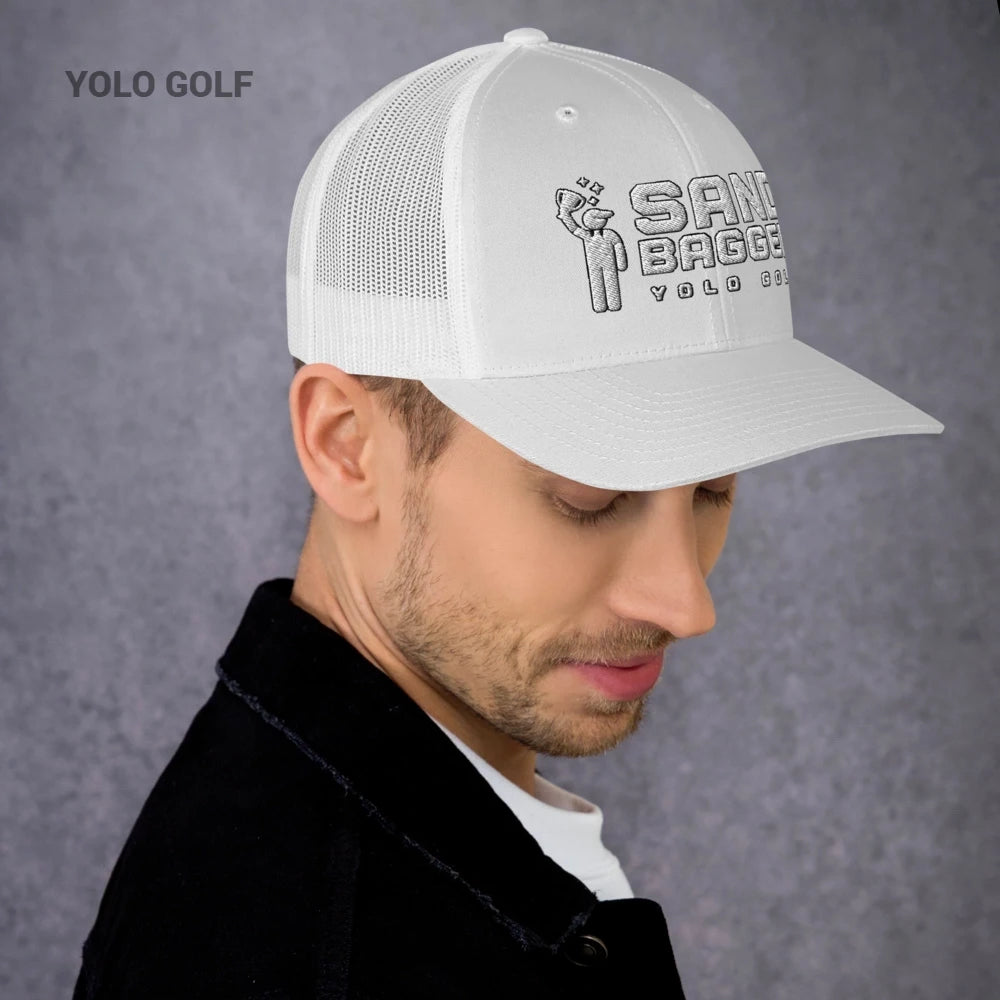 Light gray Sandbagger trucker hat worn by a man, showcasing its 