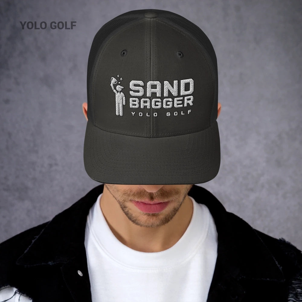 Dark gray Sandbagger trucker hat worn by a man, featuring a 