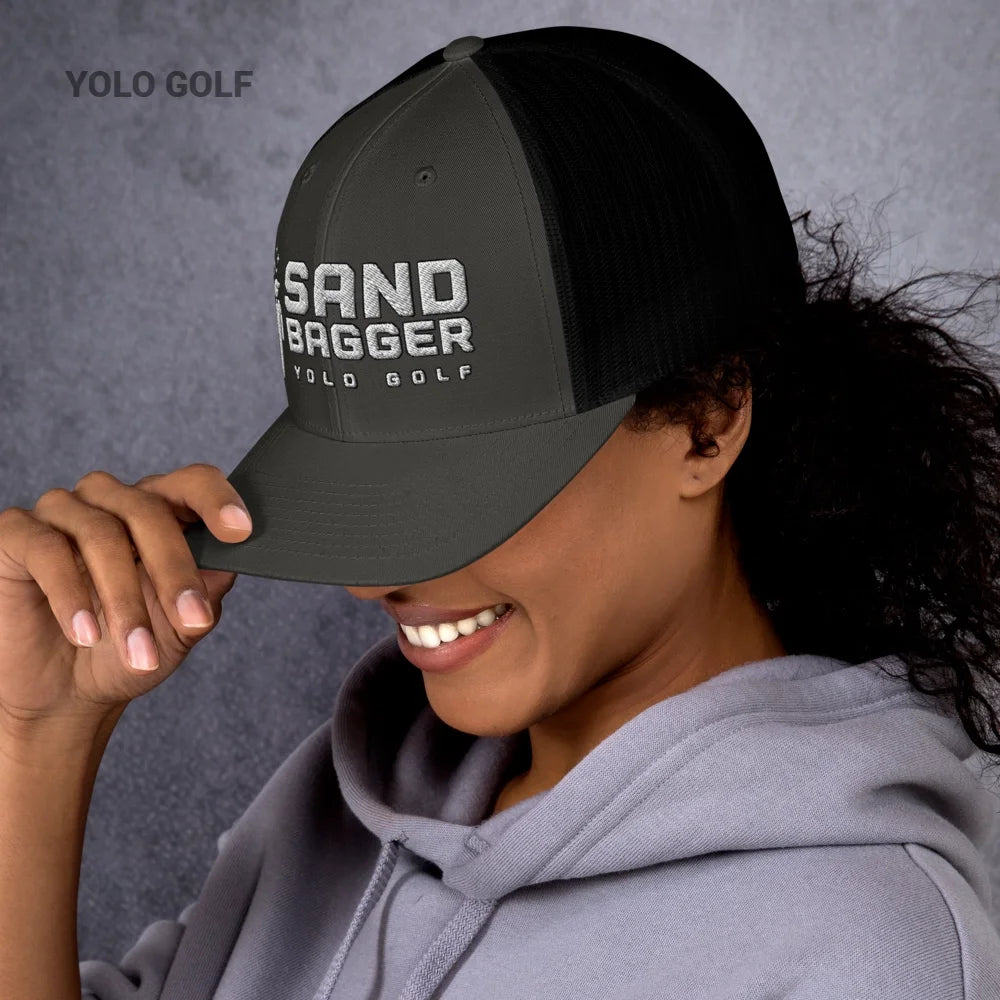 Light gray Sandbagger trucker hat worn by a smiling woman, showcasing its 