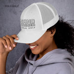 Black and white Sandbagger trucker hat worn by a smiling woman, featuring a 