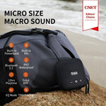 Tribit StormBox Micro 2 Bluetooth speaker displayed on a travel bag, highlighting features like IP67 waterproof, 12-hour playtime, and built-in powerbank.