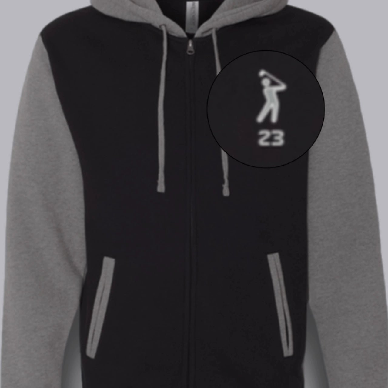 Close-up of black and gray varsity zip hoodie with embroidered golfer logo and drawstring hood from 